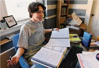  ?? ?? Grayson Hart, who directs a youth theater program, reviews sheet music. When classes went online, he spent more time pursuing creative outlets, and the stress of school faded.