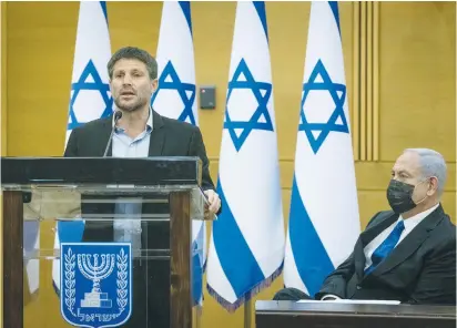  ?? (Yonatan Sindel/Flash90) ?? RELIGIOUS ZIONIST PARTY head MK Bezalel Smotrich speaks as opposition leader MK Benjamin Netanyahu looks on at an opposition meeting in the Knesset.