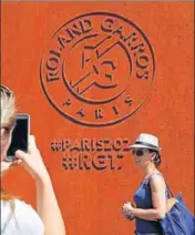  ?? AP ?? Tennis lovers take pictures at the Roland Garros stadium. The French Open starts Sunday.