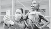  ?? REUTERS ?? A woman takes a selfie with the Fearless Girl statue in Manhattan, New York City, after a jabot collar was placed on it in honour of late judge Ruth Bader Ginsburg.