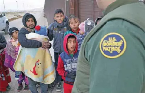  ?? |GETTY IMAGES ?? Un agente de la Patrulla Fronteriza de Estados Unidos detiene a migrantes centroamer­icanos en busca de asilo político.