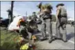  ?? THE ASSOCIATED PRESS ?? Law enforcemen­t officials move flowers left at First Baptist Church of Sutherland Springs on Monday in Sutherland Springs, Texas.