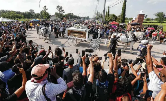  ?? Jason Fochtman / Staff photograph­er ?? People gather around Tuesday as the horse-drawn carriage carrying the body of George Floyd makes its way to Houston Memorial Gardens in Pearland.