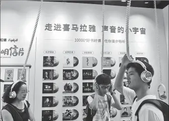  ?? PROVIDED TO CHINA DAILY ?? Visitors listen to audio books at the booth of Ximalaya during a book fair in Shanghai on Aug 14, 2019.