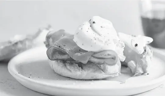  ?? SANG AN/THE NEW YORK TIMES PHOTOS ?? A poached egg and ham breakfast sandwich. The simple act of preparing a big batch of eggs teaches the importance of connecting through cooking.