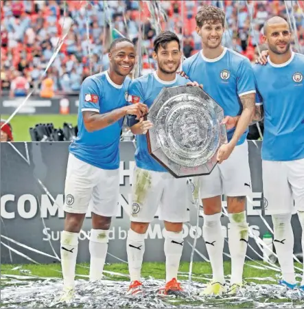  ??  ?? CAMPEONES. David Silva posa con el trofeo de la Community Shield al lado de Sterling, Stones, Walker y Rodri.