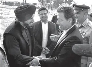  ?? PTI ?? Pakistan's PM Imran Khan shakes hands with cricketert­urnedpolit­ician, Navjot Singh Sidhu, during the ground breaking ceremony for the Kartarpur corridor, November 28