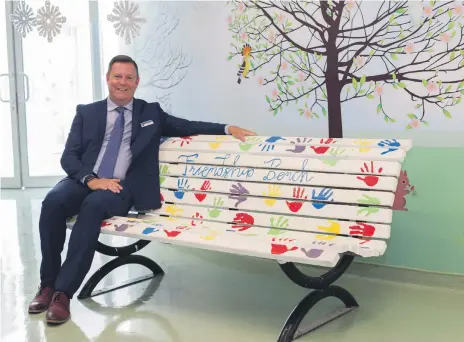  ?? Leslie Pableo for The National ?? Neil Matthews, principal at Gems Wellington Academy, on a ‘friendship bench’ where pupils can settle in