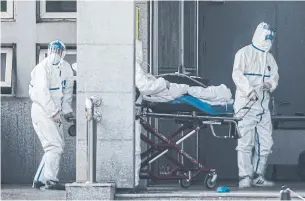  ?? AFP FILE PHOTO VIA GETTY IMAGES ?? Medical staff carry a patient into a hospital in Wuhan, China, where patients infected by what was descibed in January 2020 as a mysterious SARS-like virus were being treated.