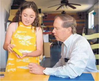  ?? GREG SORBER/JOURNAL ?? Diabetes patient Gabby Arias, 11, shows U.S. Sen. Tom Udall her insulin management system during his visit to her Rio Rancho home. Udall is concerned that conditions could become more complicate­d for Gabby and others like her if the Affordable Care Act is struck down or repealed.