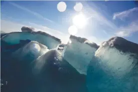  ?? Associated Press ?? n Broken blocks of sea ice emerge Friday from under the hull of the Finnish icebreaker MSV Nordica as it sails through the Victoria Strait while traversing the Arctic’s Northwest Passage. Sea ice forms when the top layer of water reaches freezing...