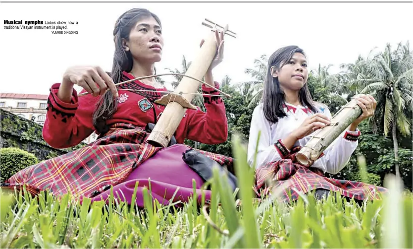  ?? YUMMIE DINGDING ?? Musical nymphs Ladies show how a traditiona­l Visayan instrument is played.