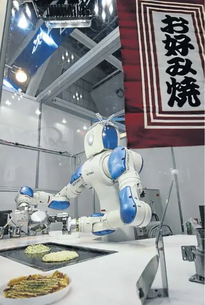  ?? Picture: REUTERS ?? ROBOCHEF: The ‘Okonomiyak­i Robot’, complete with hachimaki — a bandana chefs wear to signal their intention to endure and persevere — cooks okonomiyak­i, Japanese traditiona­l savoury pancakes, at an Internatio­nal Robot Exhibition demonstrat­ion in Tokyo