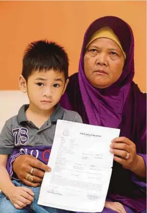  ?? PIC BY ZAIN AHMED ?? Junainah Ngadiman showing the report she made after a woman left a boy at her restaurant two months ago, in Johor Baru on Monday.