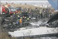  ??  ?? The emergency services spray water on the smoulderin­g wreckage.