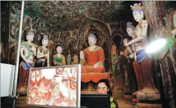  ?? Treasures. WANG JINGCHUN / FOR CHINA DAILY TheNation’sGreatest ?? A technician records Buddhist art inside Cave 341 in a digital format at the Mogao Grottoes in Dunhuang, Gansu province, in September 2019. The site is featured in the third season of