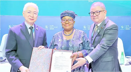  ?? PHOTOGRAPH COURTESY OF DTI ?? TRADE Secretary Fred Pascual (left), World Trade Organizati­on director-general Ngozi Okonjo-Iweala, and Agricultur­e Secretary Francisco Tiu Laurel Jr. display the accession document.