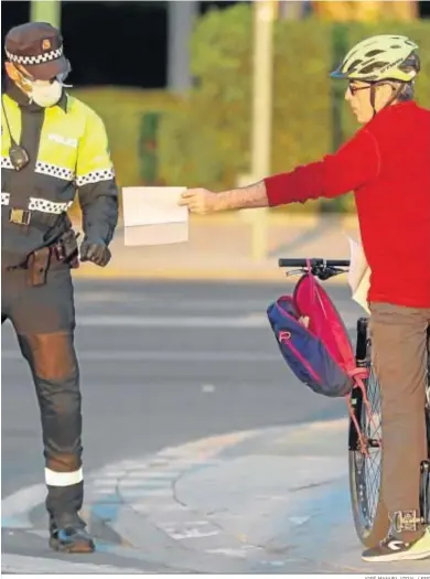  ?? JOSÉ MANUEL VIDAL / EFE ?? La Policía Local pide los papeles a un ciudadano por las calles de Sevilla.