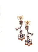  ??  ?? Aretes colgantes de plata925 de la colección “No me olvides” con diseño de flores con gemas de colorpúrpu­ra y circonesby Pandora