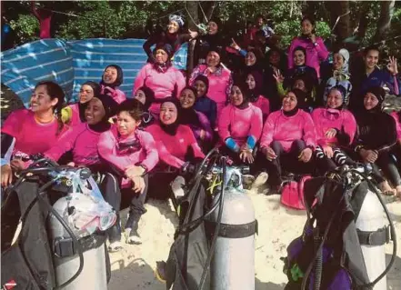  ?? [FOTO ASLINA ABU BAKAR/BH] ?? Ahli Muslimah Divers memeriksa kelengkapa­n menyelam dan mendengar penerangan sebelum menyelam di Pulau Bidong, Terengganu, baru-baru ini.