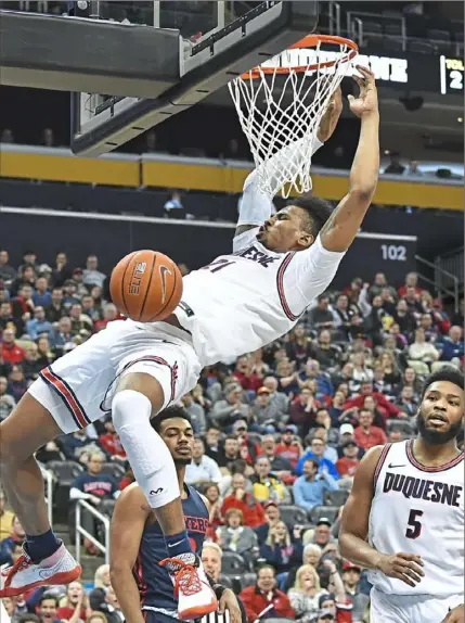  ?? Peter Diana/Post-Gazette ?? Duquesne’s Michael Hughes dunks against Dayton Wednesday night at PPG Paints Arena.