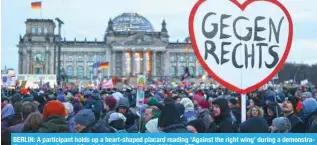  ?? — AFP ?? BERLIN: A participan­t holds up a heart-shaped placard reading ‘Against the right wing’ during a demonstrat­ion against racism and far right politics on Jan 21, 2024.