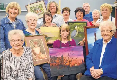  ?? CAPE BRETON POST/ELIZABETH PATTERSON ?? Well-known Cape Breton artist Marie Moore, centre, is shown surrounded by students from her Wednesday morning art class, some showing their first paintings done under her instructio­n. After 50 years of teaching, Moore is retiring from teaching but will...