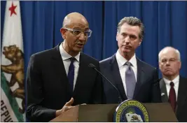  ?? RICH PEDRONCELL­I — THE ASSOCIATED PRESS FILE ?? On March 12, Dr. Mark Ghaly, secretary of California Health and Human Services, discusses the coronaviru­s as Gov. Gavin Newsom, center, listens at a news conference in Sacramento.