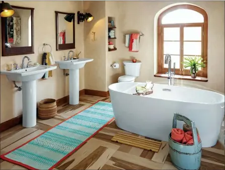  ??  ?? Homeowners can create a spalike bathroom using a luxurious freestandi­ng soaking tub as a focal point, then adding other subtle touches, such as neutral colors, adjustable lighting and open shelving to accentuate the environmen­t.