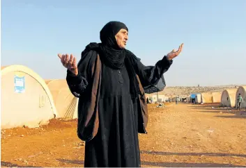  ?? IBRAHIM YASOUF/ GETTY IMAGES ?? An elderly woman stands outside tents at the Furat camp for people displaced from Deir Ezzor, in the northern Syrian province of Idlib.