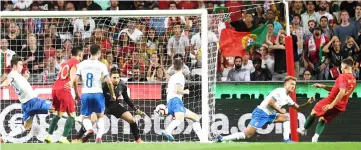  ??  ?? Andre Silva (right) kicks the ball and scores a goal during the UEFA Nations League football match between Portugal and Italy at the Luz stadium in Lisbon. — AFP photo