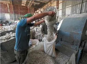  ?? — afp ?? a palestinia­n worker pouring shredded plastic for processing to extract fuel in Jabalia on the northern Gaza Strip.