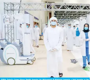  ?? —AFP ?? DUBAI: Dubai’s Crown Prince Sheikh Hamdan bin Mohammed Al-Maktoum inspects a field hospital at the Dubai World Trade Center during its inaugurati­on ceremony on Saturday.