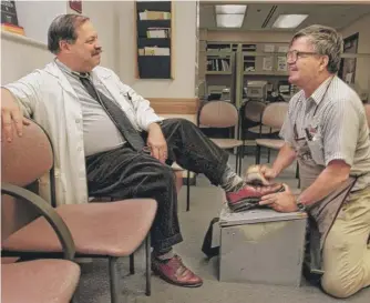  ?? BILL WADE/PITTSBURGH POST-GAZETTE VIA AP ?? Albert Lexie (right) gives a shoe shine to Dr. Samuel Kocoshis, director of gastroente­rology at Children’s Hospital of Pittsburgh, in 1998.