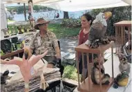  ?? MARCO SANTANA/STAFF ?? Artist John Raya speaks to his daughter, Sarah O'Hern, at Fiesta in the Park. Raya had his detailed clay figurines for sale at the event.