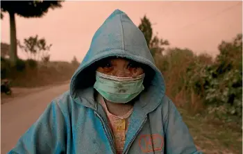  ?? PHOTO: REUTERS ?? A villager makes his way through the ash following an eruption of Mt Sinabung volcano, in Sumatra.