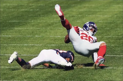  ?? Charles Rex Arbogast / Associated Press ?? Giants running back Saquon Barkley (26) is brought down by the Bears Kyle Fuller (23) on Sunday. Barkley suffered an ACL injury to his right knee in the losss and will miss the remainder of the season.