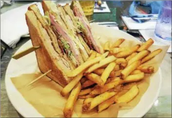  ?? MARK KOESTNER — THE NEWS-HERALD ?? The beach club sandwich at Margaritav­ille is stacked.