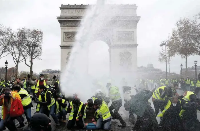  ?? STEPHANE MAHE, REUTERS ?? MANGE SKADDE: I Paris kunne man søndag ettermidda­g telle 265 skadde og 412 arresterte. Ved Triumfbuen tok politiet i bruk vannkanone­r for å jage De gule vestene på flukt.