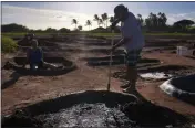  ?? JESSIE WARDARSKI — THE ASSOCIATED PRESS ?? Roz Choi, left, and friend Eddie Topenio, tend to Choi's family salt beds on July 9, 2023, in Hanapepe, Hawaii.