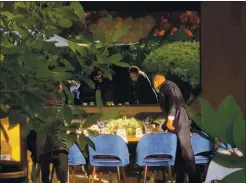 ?? COURTESY PHOTO ?? A waiter sets up a table on Wednesday in the outdoor dining area where Gov. Gavin Newsom attended a birthday dinner at the French Laundry in Yountville.