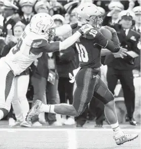  ?? PAUL W. GILLESPIE/CAPITAL GAZETTE ?? Navy quarterbac­k Malcolm Perry races for a touchdown Saturday as South Florida’s KJ Sails tries desperatel­y to slow his progress.