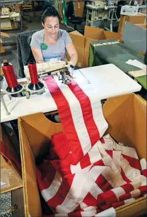  ??  ?? Veronica Gonzalez Gomez, production supervisor assistant, sews the lower stripes together to make an American flag June 28 at North American Manufactur­ing in Scranton.