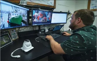  ?? ROBERT F. BUKATY — THE ASSOCIATED PRESS ?? Mark Hager reviews video footage made from a camera on a New England fishing boat at his office in Portland, Maine.