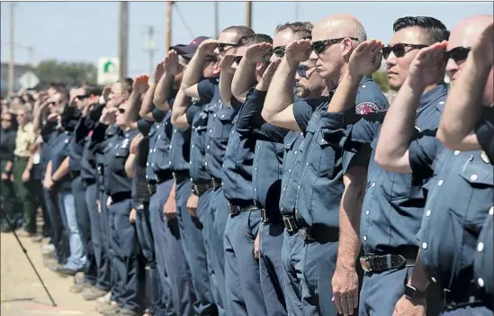  ?? Christophe­r Chung The Press Democrat ?? A PROCESSION for Utah Battalion Chief Matthew Burchett draws salutes in Ukiah. This has been a hard year for firefighte­rs in California. A Redding firefighte­r, a bulldozer operator and a Pacific Gas &amp; Electric utility worker died during the Carr fire in Shasta County. Two more firefighte­rs died in the Ferguson fire in Yosemite.