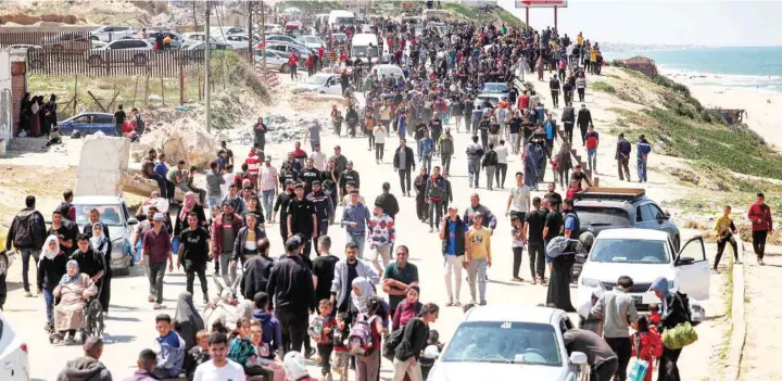  ?? — AFP ?? Displaced Palestinia­ns take the coastal Rashid road to return to Gaza City.