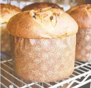  ?? Contribute­d photo ?? Wave Hill panettone is a seasonal favorite and perfect for French toast. Below, a customer fills up a bag with loaves of bread.