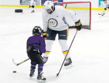  ?? PIERRE OBENDRAUF ?? Nashville Predators’ P.K. Subban gives pointers to young players during his hockey clinic in Pierrefond­s on Saturday.