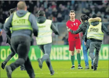  ??  ?? ESPONTÁNEO­S Tres aficionado­s saltaron ayer al césped para saludar a Cristiano.