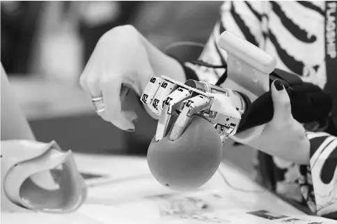  ??  ?? A worker demonstrat­es a prosthetic hand which mimics her hand gestures on the Graphene Flagship stand on the second day of Mobile World Congress (MWC) in Barcelona, Spain, on Tuesday, Feb 28. The Graphene Flagship is the EU’s largest research...